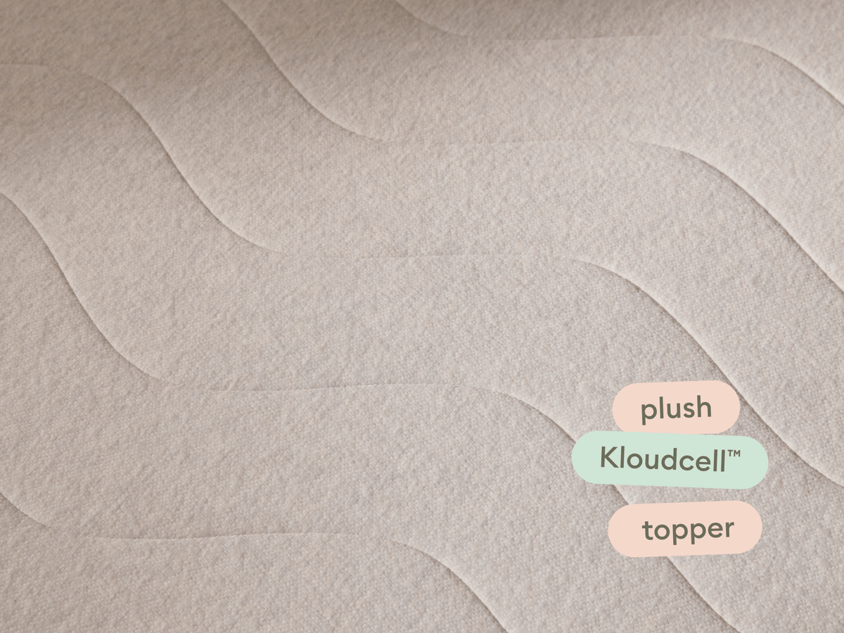 Beige mattress topper with plush Kloudcell™ material, featuring a gentle wave pattern. Ideal for enhancing bedding comfort in luxurious settings.