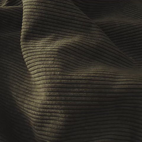 close up of dark green corduroy fabric in sunny room